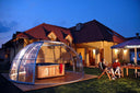 Outdoor-Whirlpool unter transparenter Überdachung in einem Garten bei Dämmerung