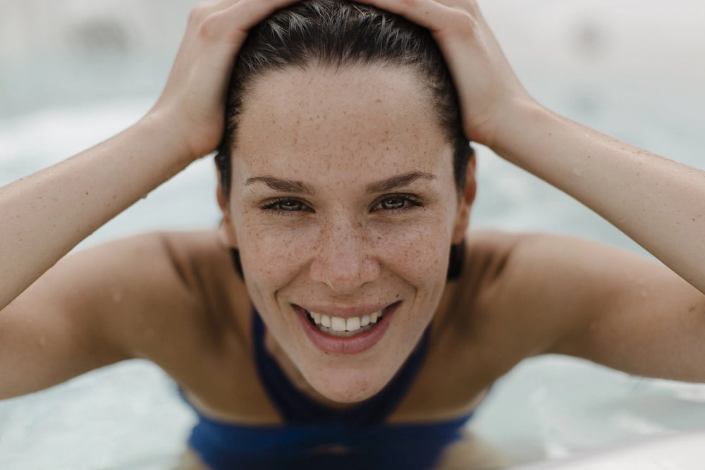 Lächelnde Frau im Wasser eines Swim Spas