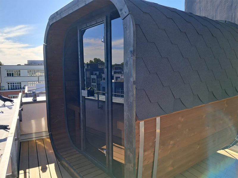 Abgerundete Kaunis Gartensauna mit Glasfront auf einer Dachterrasse über der Stadt