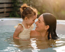 Mutter und Kleinkind sitzen gemeinsam im Whirlpool