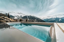Swim Spa mit Blick auf verschneite Berge und ein alpines Tal