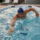 Mann mit Schwimmbrille und Badekappe schwimmt im VIVO SPA WaterFit 1