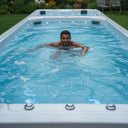 Mann schwimmt im langen, blau beleuchteten Schwimmbereich des VIVO SPA WaterFit 2N