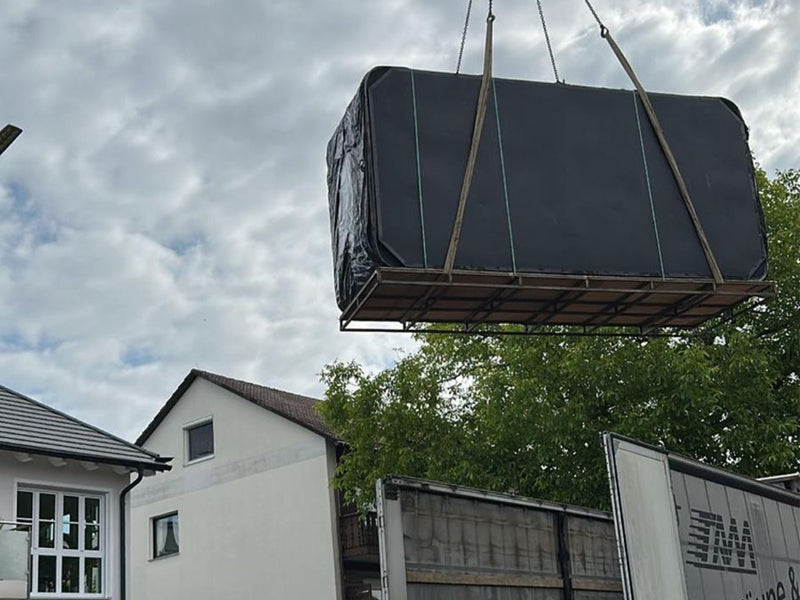 Verpackter VIVO SPA Waterfit Swim-Spa wird über einen Lkw hinweg zu einem Wohnhaus gehoben