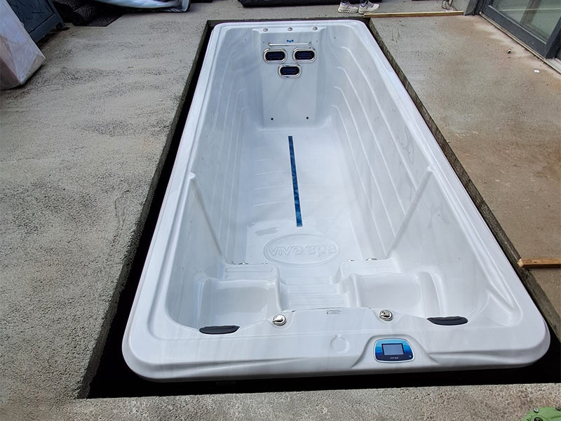 Leerer VIVO SPA Waterfit Swim-Spa in einer Bodenöffnung, Draufsicht auf Innenbecken und Düsen