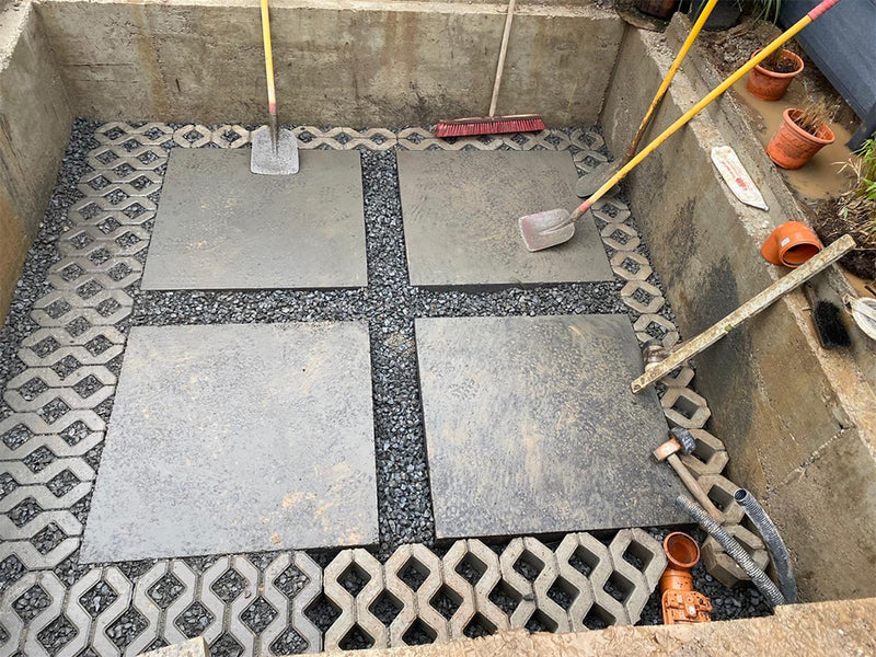 Vorbereitete Baugrube für einen Whirlpool mit Betonplatten, Kies und Drainage