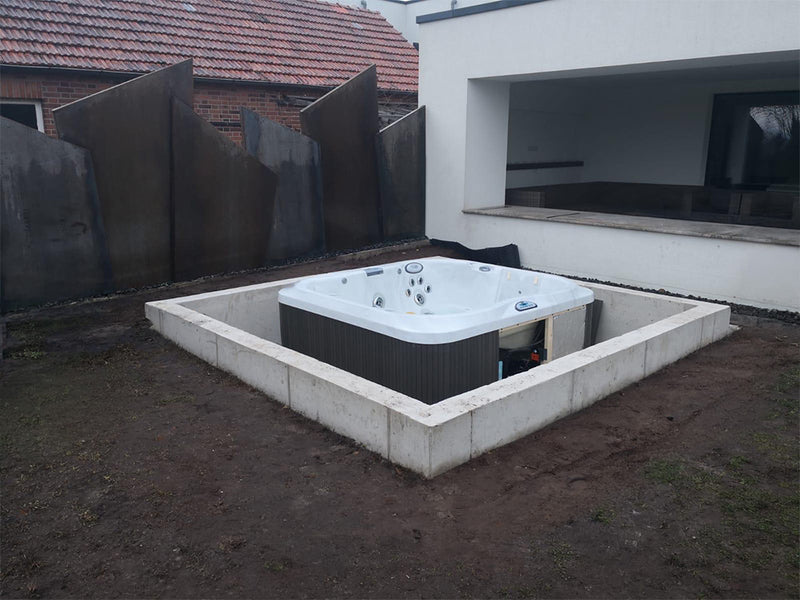Whirlpool bei der Teileinlass-Montage in einem rechteckigen Betonfundament