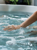 Hand gleitet durch sprudelndes Wasser in einem Whirlpool
