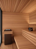 Innenraum der AUROOM Mira L mit Holzofen und breiten Saunabänken aus Thermo-Espe