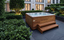 USSPA Virgo Whirlpool mit Holzverkleidung und Stufen in einem modernen Garten