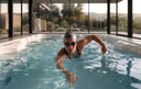 Schwimmerin mit Badekappe und Schwimmbrille trainiert in einem Indoor-Swim-Spa