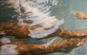 Mehrere Personen strecken ihre Arme unter Wasser zur Mitte eines Whirlpools