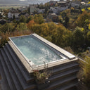 USSPA Swim Spa XL auf einer abgestuften Holzterrasse am Hang mit teilweise geschlossener Abdeckung