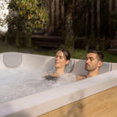 Paar entspannt im sprudelnden VIBES by USSPA Natura Whirlpool im Garten