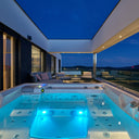 Blau beleuchteter USSPA Persea iN Whirlpool auf einer modernen Terrasse bei Nacht