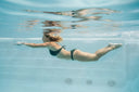 Frau schwimmt unter Wasser in einem Swimspa mit Gegenstromanlage