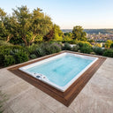 In eine Holzterrasse eingelassener VIVO SPA AUREA chill mit Blick über einen begrünten Stadthang