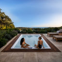 Zwei Frauen im eingelassenen VIVO SPA AUREA chill auf einer Holzterrasse mit Meerblick