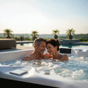 Paar im sprudelnden VIVO SPA AUREA 6 Whirlpool auf einer Terrasse mit Außenpool