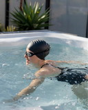 Schwimmerin mit Badekappe und Schwimmbrille in einem Swim Spa