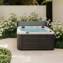 VIVO SPA WELUXIA 503 N Whirlpool mit geöffneter Abdeckung in einem Garten mit weißen Blüten