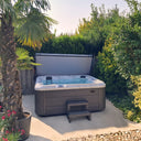 VIVO SPA WELUXIA 504 N Whirlpool mit Einstiegstreppe und geöffneter Abdeckung im Garten