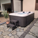 VIVO SPA WELUXIA 505 N Whirlpool mit Einstiegstreppe auf einer Steinterrasse