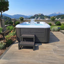 Sprudelnder VIVO SPA WELUXIA 506 N Whirlpool mit Einstiegstreppe und Bergblick
