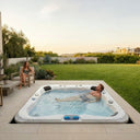 Mann entspannt im eingelassenen VIVO SPA WELUXIA 514 N Whirlpool auf einer Gartenterrasse