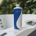 Flasche SpaBalancer Basic auf dem Rand eines weißen Whirlpools