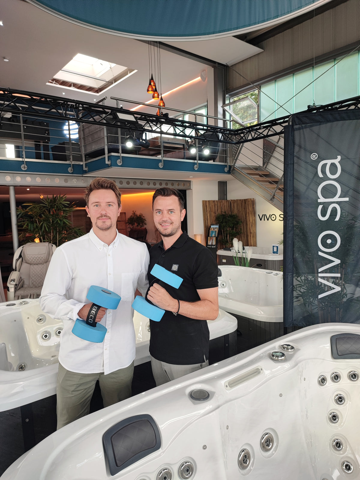 Dennis Buck und Florian Öttking im Whirlpool-Center-Showroom mit Aquafitness-Hanteln